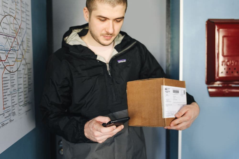 An GoGoX staff member scanning a parcel label with a handheld device at the counter.