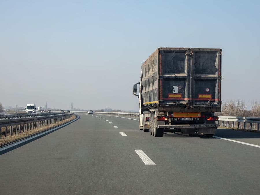A long-haul freight truck on a motorway carrying a double container load.